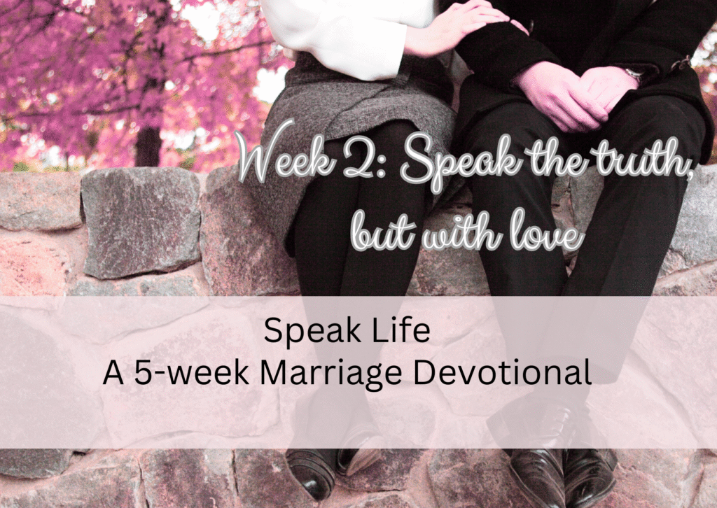 couple holding hands sitting on a wall