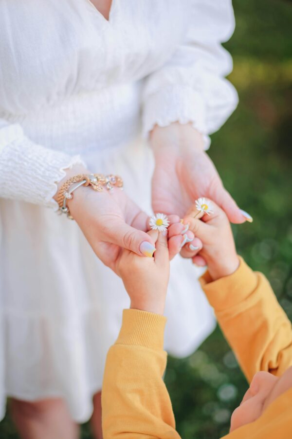 Child offering daisies to a woman in a tender moment. Perfect for expressing love and connection.